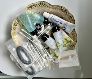 A tray with various personal care items including a bottle of Sensodyne toothpaste, a bottle of Dove body wash, and other toiletries. - Freshwater - Hot Tub - Pet Friendly - Garden (Freshwater)