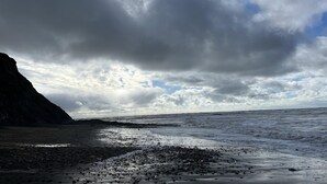 A rocky beach with a large cliff on the left and a cloudy sky above. - Freshwater - Hot Tub - Pet Friendly - Garden (Freshwater)