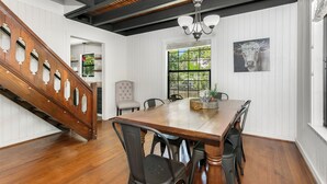 A dining area with a wooden table, chairs, and a chandelier.