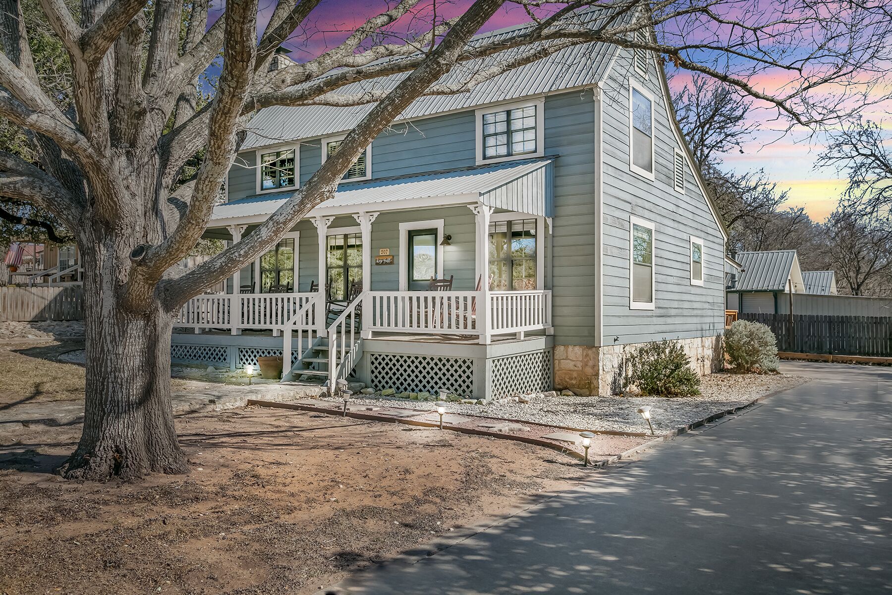 A two-story house with a porch, a covered front entrance, and a small front yard.