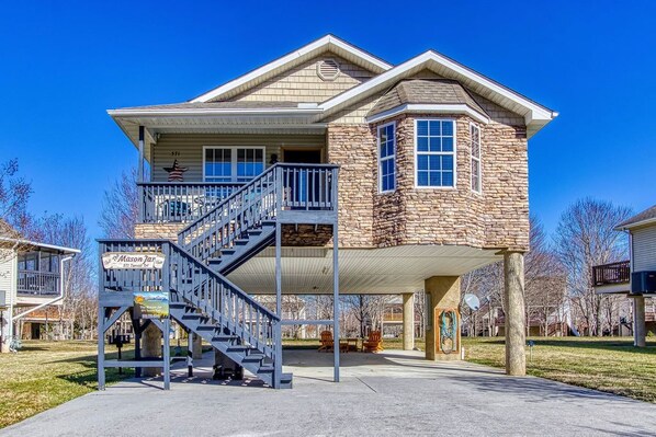 A two-story house with a stone facade, a covered porch, and a staircase leading to the upper level. - The Mason Jar, Hot Tub,WIFI, $560 In tickets each paid day! (Pigeon Forge)