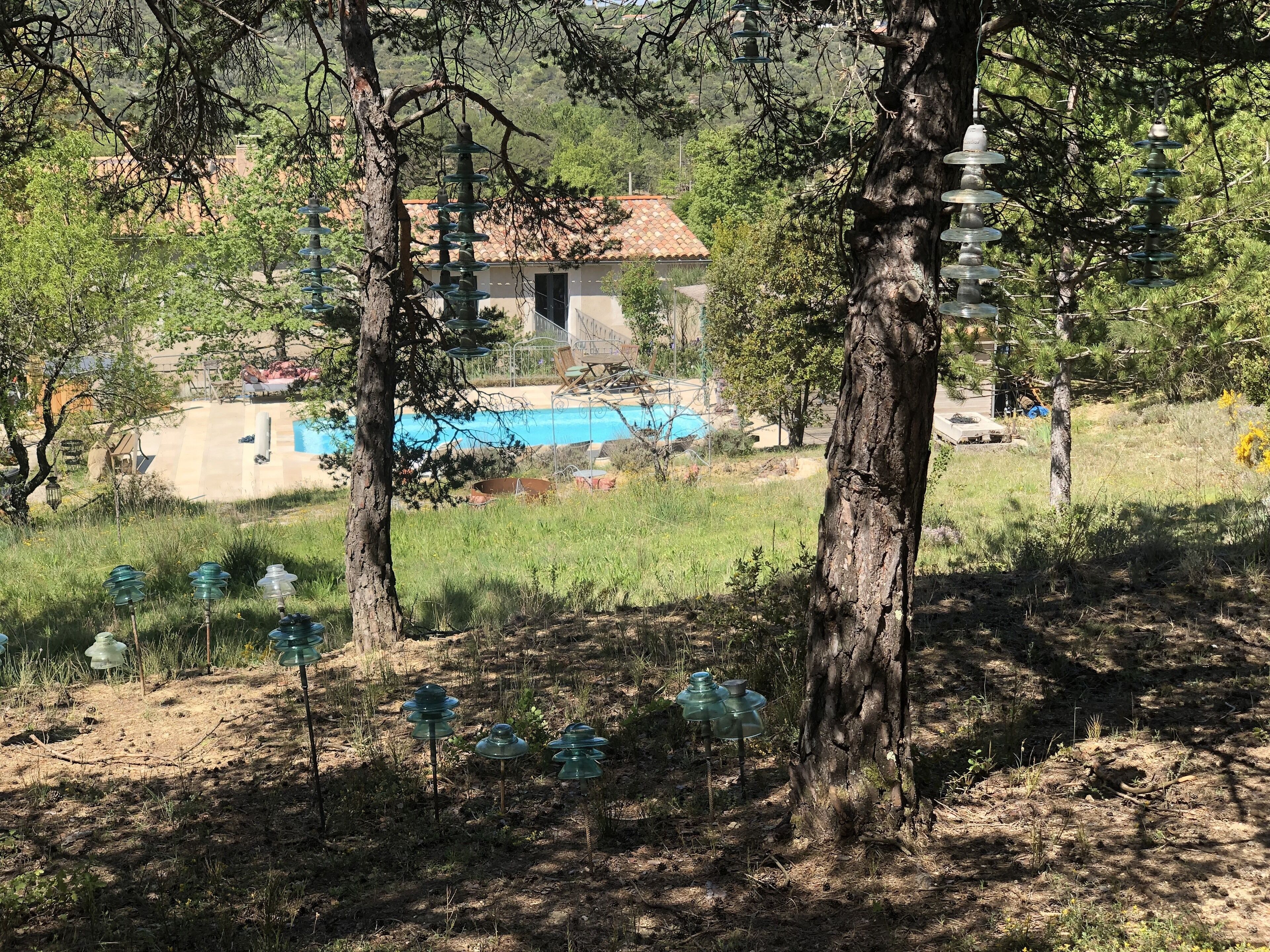 A residential area with a swimming pool, trees, and outdoor lighting fixtures.