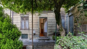 Un edificio de piedra con puerta de madera y escalones que conducen a un porche cubierto.