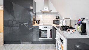 A modern kitchen with a built-in oven, microwave, and coffee maker. - Comfortable 2BR Apartment in Bedford (Bedford)