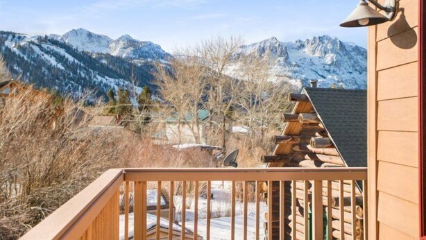 A wooden cabin with a balcony overlooking snow-covered mountains. - Hudson Hideaway, your home away from home (June Lake)