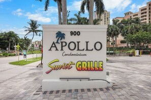 A sign for Apollo Condominium with the Sunset Grille.