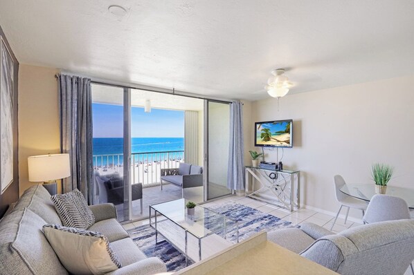 A modern living room with a sofa, coffee table, and a TV on the wall.