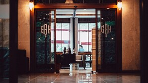 A hotel entrance with a polished marble floor, a reception desk, and a large chandelier. - Grand Selale Hotel (Çayeli)