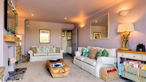 A living room with two white sofas, a wooden ottoman, and a lamp. - Stunning house, river views, 3 balconies, Fowey (Fowey)
