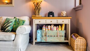 A living room with a white sofa, a wooden side table with a lamp, and a basket. - Stunning house, river views, 3 balconies, Fowey (Fowey)