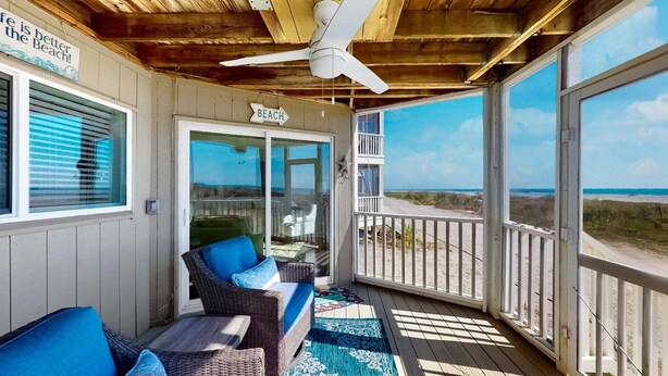 A covered porch with wicker furniture, a ceiling fan, and a view of the beach. - Captivating oceanfront in this 1st floor condo in Wild Dunes (Island Of Palms)