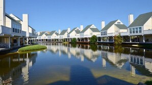A row of waterfront houses with a calm river in the foreground. - Hoosier Holiday 1 Bedroom Condo by RedAwning (Destin)