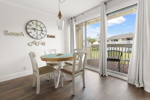 Enjoy a room with a large window, balcony, and modern decor, featuring a round table and comfortable seating for four.
