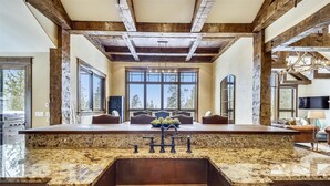 A kitchen with a large island, wooden beams, and large windows. - The Great Escape: Breckenridge Home with Hot Tub and Mountain Views (Breckenridge)