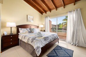 A bedroom with a bed, nightstands, a lamp, a picture on the wall, and a view of the outside. - Sweet 2 bedroom walking distance to Eagle Beach (Eagle Beach)