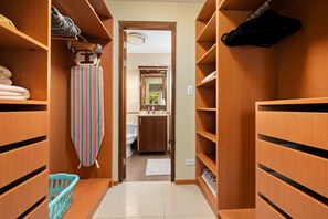 A narrow hallway with wooden shelving on both sides, leading to a bathroom with a sink and mirror. - Sweet 2 bedroom walking distance to Eagle Beach (Eagle Beach)
