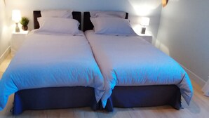 A double bed with a dark headboard and two bedside lamps.