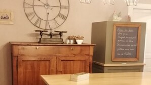 A kitchen with a wooden cabinet, a large clock, and a chalkboard with writing.