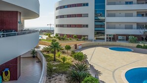 Un bâtiment moderne doté de nombreux balcons et d’un espace piscine.