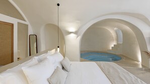 Una camera d'albergo moderna con un letto grande, un bagno piccolo e vista su una piscina.