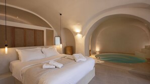 Una camera da letto moderna con un letto grande, una vasca idromassaggio integrata e un design minimalista.