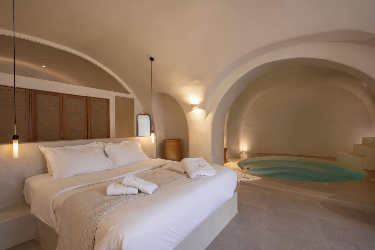 Ein modernes Schlafzimmer mit einem großen Bett, einer integrierten Badewanne und einem minimalistischen Design.