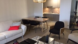 Ein modernes Wohnzimmer mit einer Couch, einem Couchtisch und einem Essbereich mit Stühlen und einem Tisch.