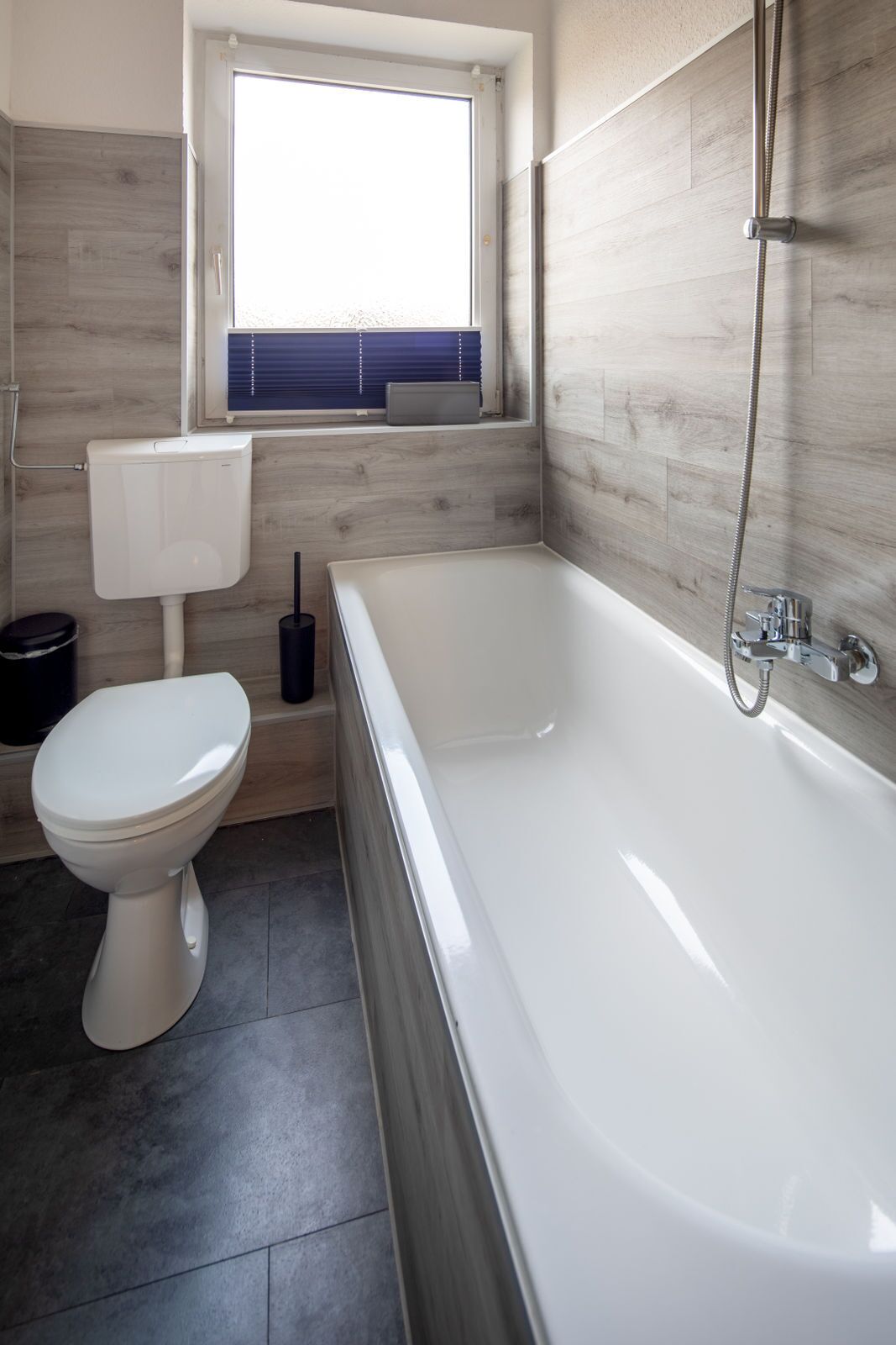 Un baño moderno con inodoro, bañera y ventana.