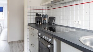 Een moderne keuken met witte kasten, een zwart aanrecht en een roestvrijstalen spoelbak.