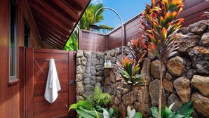 A wooden gate with a towel hanging on it, a stone wall, and tropical plants. - Hale Kai Malia: Spacious, Stylish Ocean View Villa (Koloa)