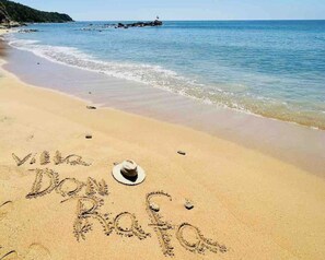 A beach with the words "villa Dona Rosa" written in the sand, a hat, and a rocky outcrop in the background. - Beach Villa Don Rafa with pool and 5-bedrooms (Yabucoa)
