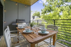A dining table set with plates, bowls, cutlery, and glasses on a balcony with a view of trees and buildings. - 🥳​🎉24 Beds.  Large CELEBRATION Home.  5 Points Section.  Close to the Heart of T (Nashville)