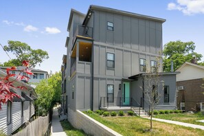 A multi-story residential building with a modern design, featuring a central staircase, a small front porch, and a visible fire escape. - 🥳​🎉24 Beds.  Large CELEBRATION Home.  5 Points Section.  Close to the Heart of T (Nashville)
