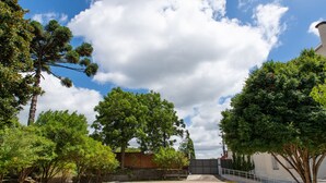 An outdoor parking area with trees and a clear sky. - Pousada dos Frades (Garibaldi)