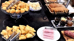 A buffet table with various food items including pastries, sandwiches, and fruits. - Pousada dos Frades (Garibaldi)