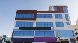 A multi-story hotel with a modern design, featuring large windows and a sign for 'J.A. Royal Suites'. - Itsy Hotels J A Royal Suites Manikonda (Hyderabad)