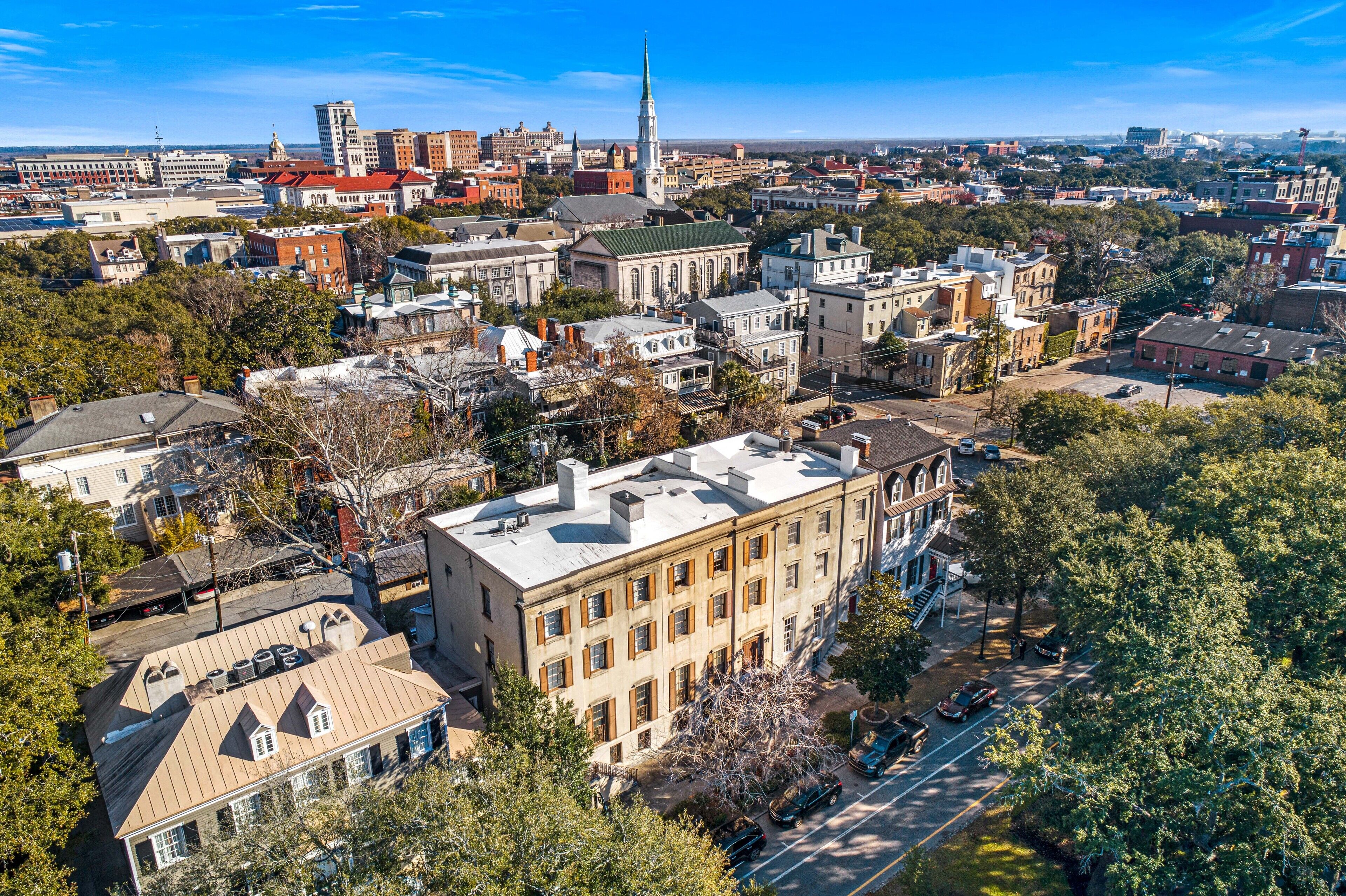 An aerial view of a historic downtown area with a mix of architectural styles, including a prominent church steeple.