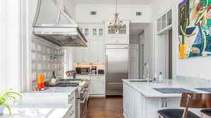 Una cocina moderna con armarios blancos, electrodomésticos de acero inoxidable y encimera de mármol.