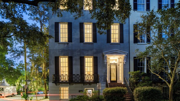 A two-story building with a central entrance, a balcony, and multiple windows. - Exquisite Historic Mansion on Beautiful Pulaski Square by Lucky Savannah (Savannah)