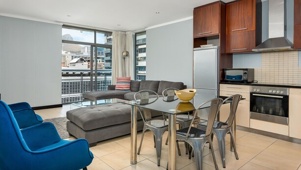 Una cocina moderna con comedor, ventanas amplias y vista a la ciudad.