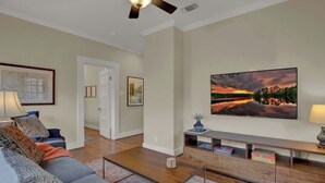 A living room with a sofa, coffee table, and a flat-screen TV on a stand.