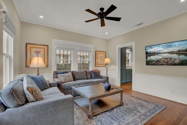 A spacious living room with a gray sofa, a coffee table, and two lamps.