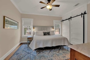 A bedroom with a bed, a ceiling fan, a window, and a sliding door. - 500 Feet 2 Main St-Fred Charmer! (Fredericksburg)