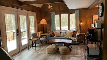 Relax in this inviting living room with a comfortable sofa, coffee table, and two wicker ottomans.