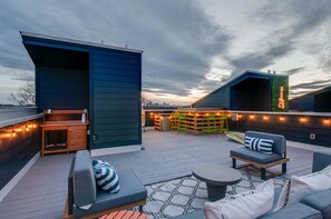An outdoor deck with seating, a bar area, and string lights.