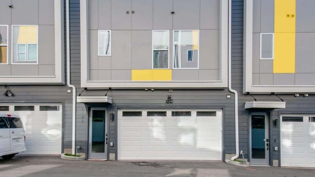 A multi-story residential building with a garage on the ground floor.