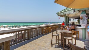A beachside bar with outdoor seating overlooking the ocean. - Silver Shells St Lucia 501 - Beachfront, Heated Community Pool + Hot Tub! (Destin)