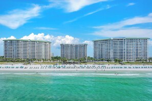 A beachfront hotel with multiple high-rise buildings, a sandy beach, and clear turquoise waters. - Silver Shells St Lucia 501 - Beachfront, Heated Community Pool + Hot Tub! (Destin)