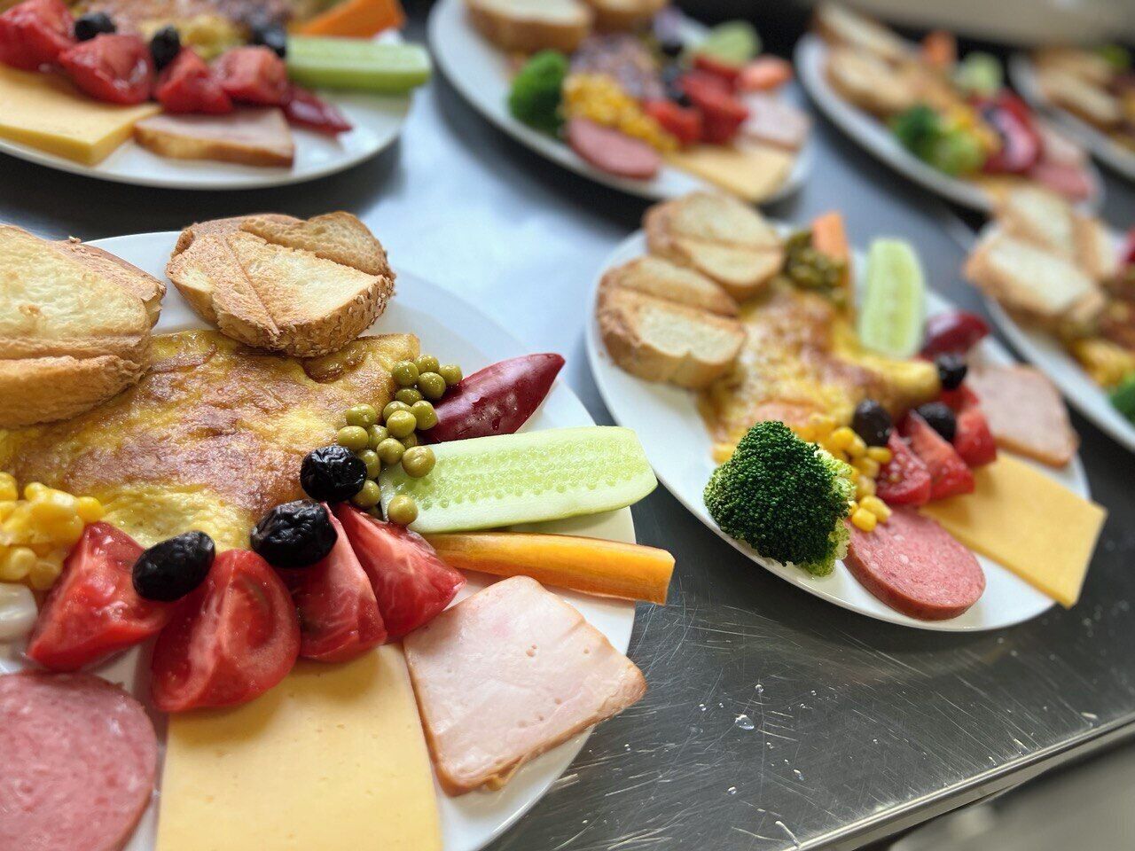 En buffet med forskellige spiser, herunder kød, oste og grøntsager.