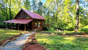 A rustic cabin with a red roof, surrounded by a forest. - Hocking Hills secluded Mayapple Cabin - 8 miles from Cantwell Cliffs! ~Hot Tub~ (Rockbridge)